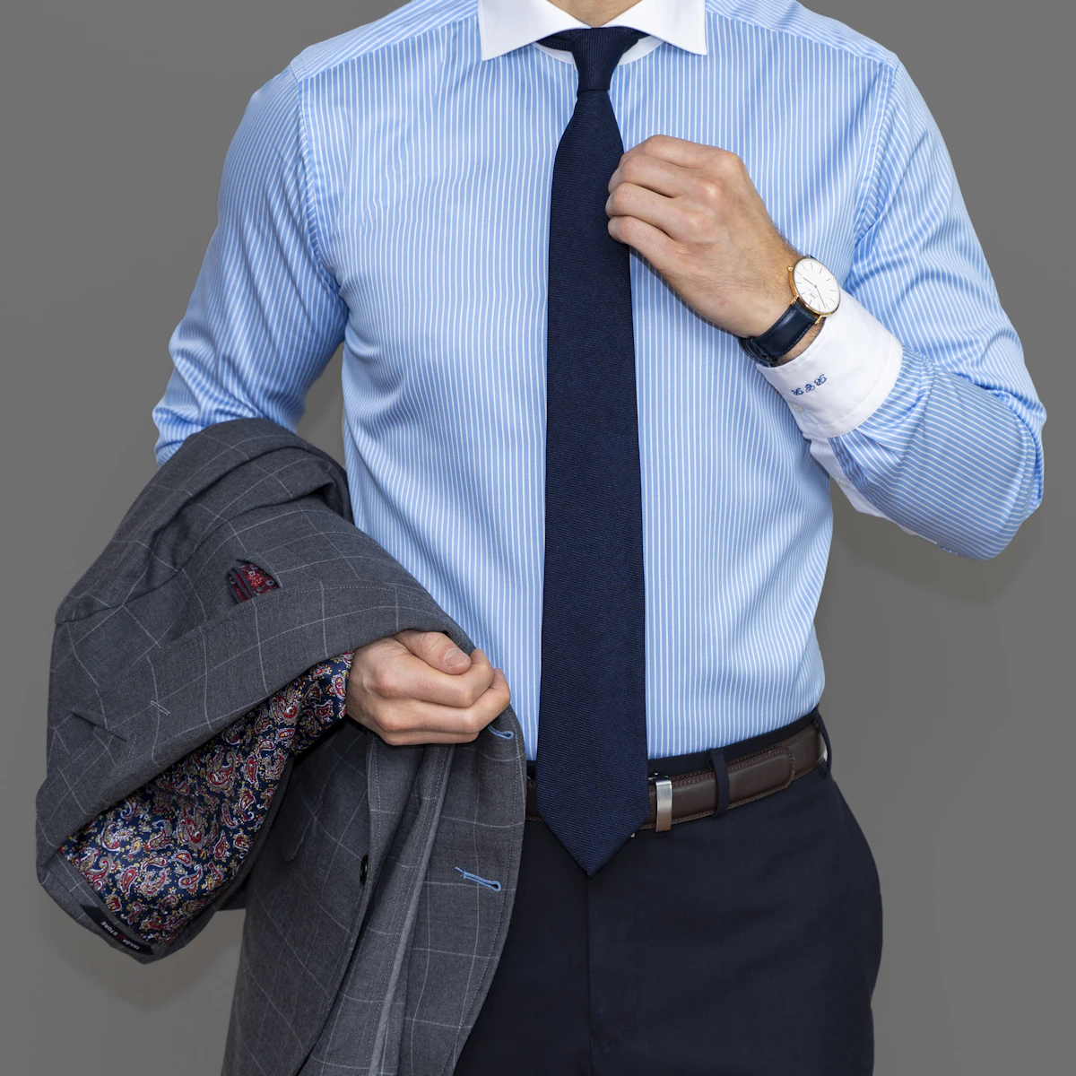 A crisp white tailored dress shirt folded on a wooden surface